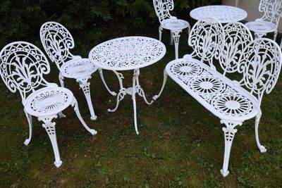 quatre chaises blanches et une table dans le jardin