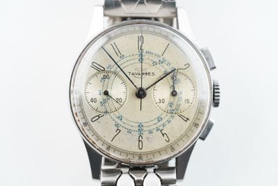 une montre posée sur un support sur une surface blanche