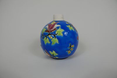 un petit vase bleu orné d'un motif floral
