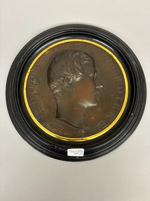 a bronze medallion of a man with a crown on it