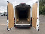 the back of a white van with its doors open in a parking lot
