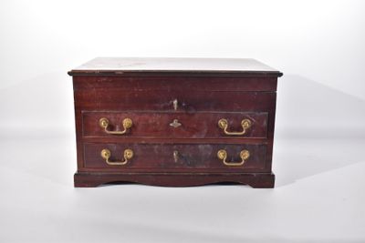 une vieille commode en bois avec des poignées en laiton sur fond blanc