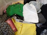 a pile of clothes that is sitting on a bed
