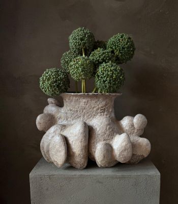 un vase contenant du brocoli, posé sur un bloc