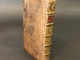 an old book sitting on top of a table next to a gray wall