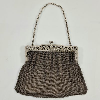 un vieux sac à main auquel est accrochée une chaîne sur le côté