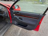 a red car with the door open and the driver ' s seat down