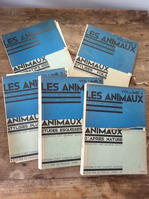 quatre livres posés sur une table en bois, avec des couvertures bleues