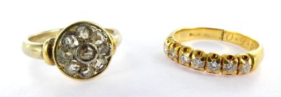 two gold rings with diamonds on them sitting next to each other