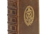 un vieux livre orné d'un emblème doré sur la couverture