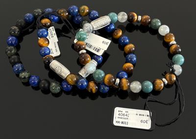 deux bracelets de couleurs différentes, munis d'étiquettes, posés sur une surface noire