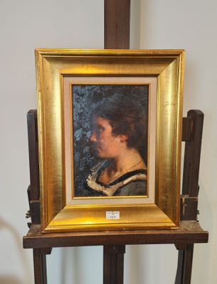 un tableau représentant une femme en robe noire posée sur un chevalet