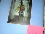 a picture of a woman sitting in a window sill
