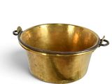 a small brass pot with a handle on a white background