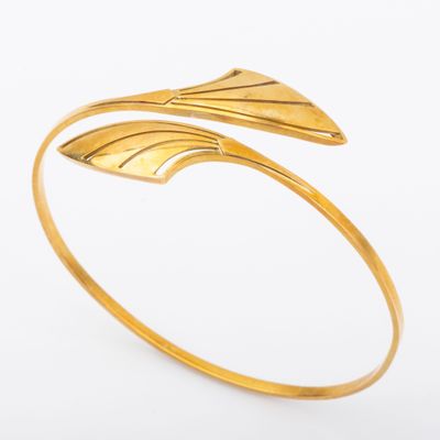 a gold cuff bracelet with a leaf design on it