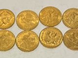a group of six gold coins sitting on top of a white surface