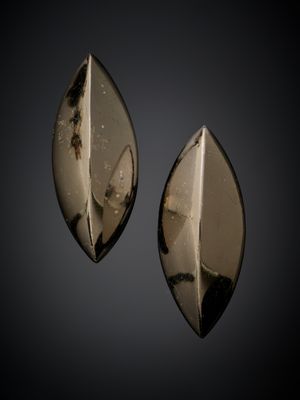 une paire de boucles d'oreilles en verre noir et blanc sur fond noir