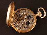 a close up of a pocket watch on a black surface