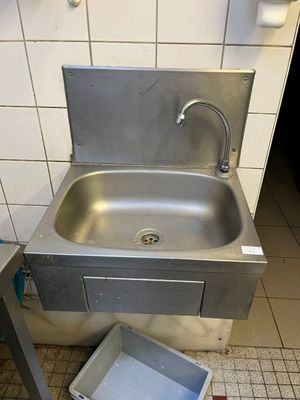 un lavabo et une poubelle dans des toilettes publiques