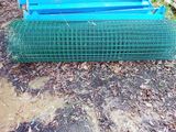 a blue bench sitting on the ground next to a green fence