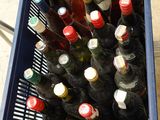 many bottles of wine in a blue crate on the floor