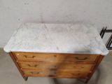 a marble top dresser in the corner of a room