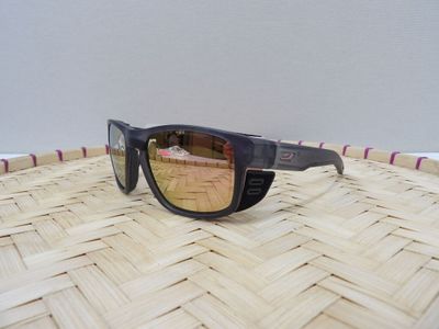 une paire de lunettes de soleil posée sur un panier tressé