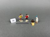 trois figurines représentant des personnes debout les unes à côté des autres