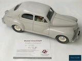 a silver toy car with a man in the driver ' s seat