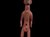 une statue rouge représentant un homme coiffé d'un chapeau