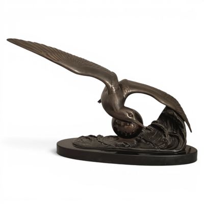 a bronze statue of an eagle on a wave with its wings spread