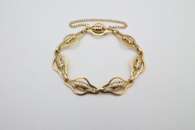 un bracelet en or au motif torsadé sur fond blanc