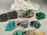 several different colored rocks and crystals on a white surface