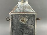 an old metal lantern with a metal handle on a gray background