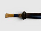 a wooden baseball bat with a blue handle on a white surface