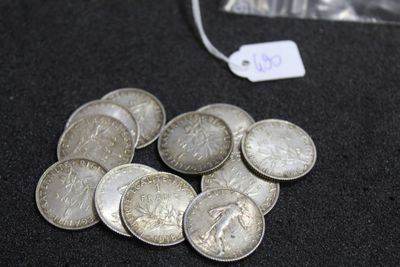 a pile of silver coins on a black surface