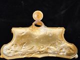 gold plate with a picture of a woman and a man in a boat