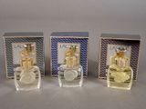 three bottles of perfume sitting on top of a table next to each other