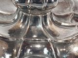 a silver vase that has a clock on top of it