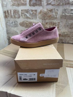 pair of pink slip on shoes sitting on top of a cardboard box
