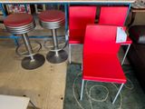trois chaises rouges et deux tabourets dans une pièce