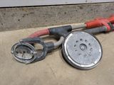 an image of a hose and a sander laying on the ground