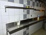 a kitchen with a stainless steel counter top and a stainless steel shelf