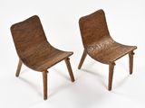pair of wooden chairs with bent legs on a white background