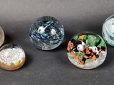 several glass marbles are lined up on a black surface