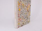 a white book with flowers on it sitting on a white surface
