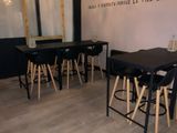 tables and stools in a room with a mirror on the wall