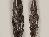 deux sculptures sur bois représentant un homme et une femme sur fond blanc