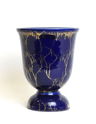 a blue vase with a gold leaf design on it