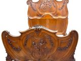 a wooden bed with a carved headboard and foot board